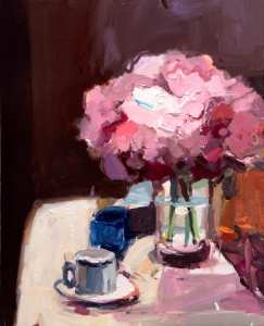 Pink Hydrangeas in vase on white tablecloth with white cup and blue bowl