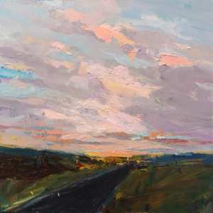 dark grey road receding into cloudy sky with pinks and lavenders