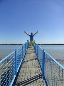 Man on a pier jumping for joy 